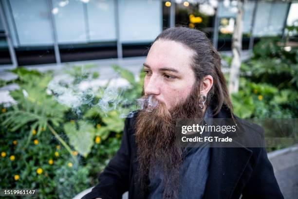 mid adult man smoking outdoors - emo guy stock pictures, royalty-free photos & images