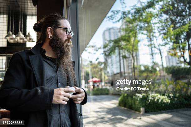 mid adult man contemplating at coffee shop - emo guy stock pictures, royalty-free photos & images