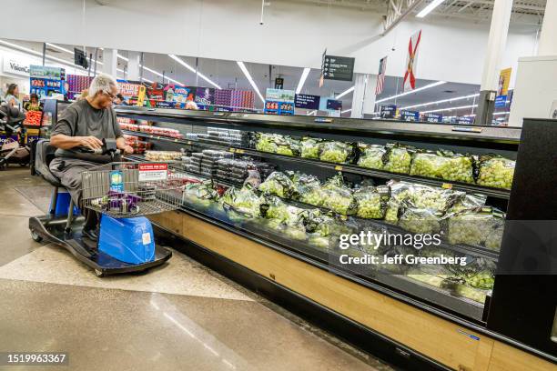 Miami, Florida, Doral, Walmart store, disabled shopper riding electric cart in produce aisle.