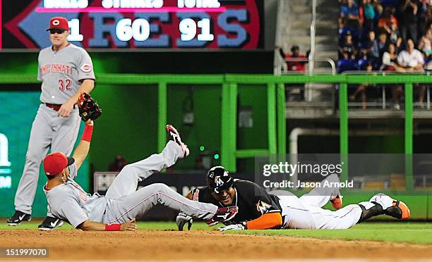 Carlos Lee of the Miami Marlins is tagged out at second base by shortstop Wilson Valdez of the Cincinnati Reds as Jay Bruce looks on at Marlins Park...