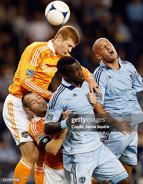 Andre Hainault of the Houston Dynamo battles Brad Davis, C.J. Sapong, and Aurelien Collin of Sporting KC for a header during the MLS game at...