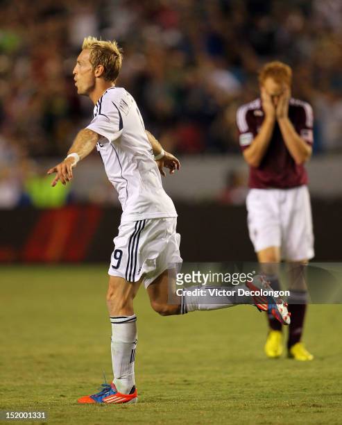 Christian Wilhelmsson of the Los Angeles Galaxy celebrates his goal in the second half as Jeff Larentowicz of the Colorado Rapids reacts dejectedly...