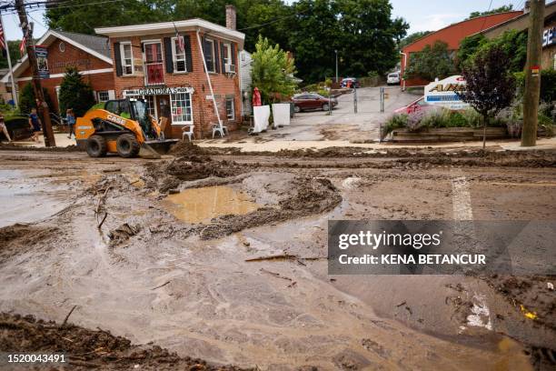 Workers remove mud from Main street after heavy rains in Highland Falls, New York, on July 10, 2023. The northeastern United States was inundated...