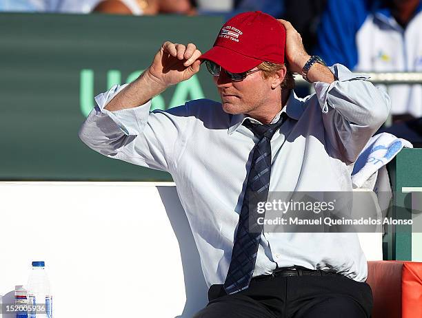 Team captain Jim Courier of the United States puts on his cap during day one of the semi final Davis Cup between Spain and the United States at the...