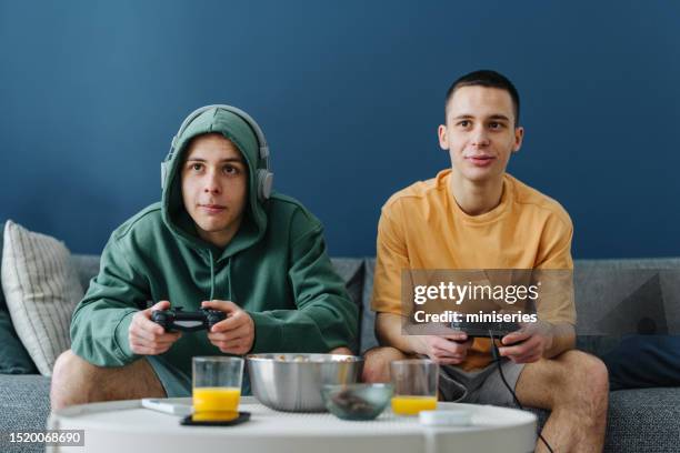 twins playing video games at home - adrenaline junkie stock pictures, royalty-free photos & images