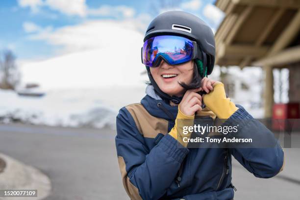 young woman preparing to snowboard - ski goggles stock pictures, royalty-free photos & images