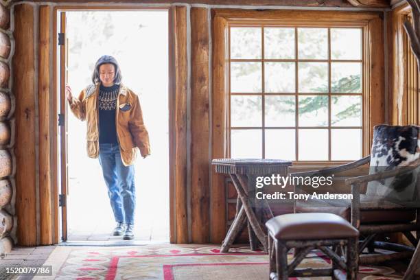 young woman entering cabin - winter holiday stock pictures, royalty-free photos & images