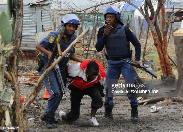 South African police arrest a miner in Marikana on September 15, 2012 at Lonmin's platinum mine, seizing traditional weapons after hundreds of...
