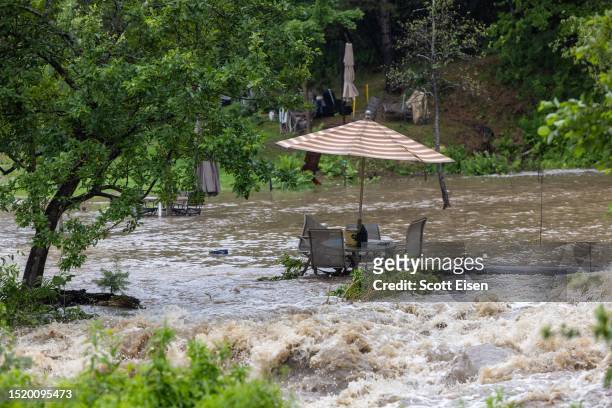Yard is flooded by rushing water on July 10, 2023 in Londonderry, Vermont. Torrential rain and flooding has affected millions of people from Vermont...