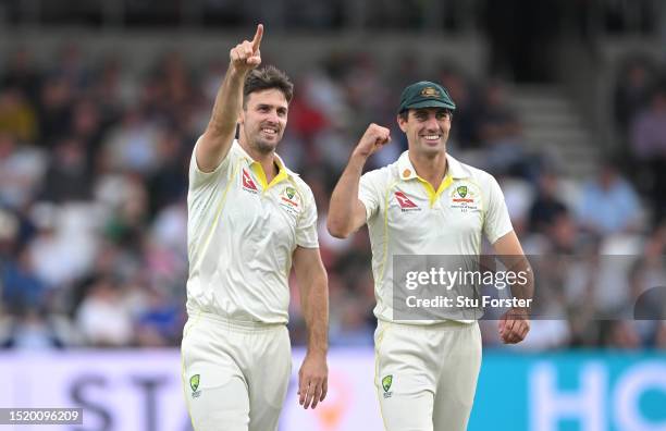 Australia bowler Mitchell Marsh and captain Pat Cummins celebrate towards the players balcony after Marsh had taken the wicket of Zak Crawley during...