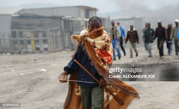 Striking miner stands after South African police fired tear gas in Marikana on September 15, 2012 at Lonmin's platinum mine after hundreds of workers...