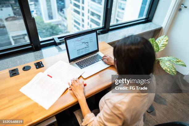 mature businesswoman working using laptop at office - spreadsheet stock pictures, royalty-free photos & images