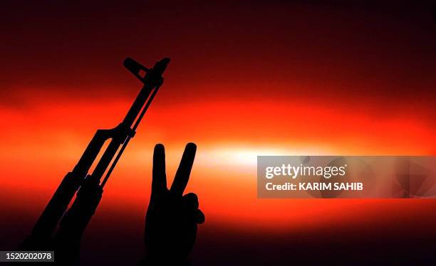 Libyan National Transitional Council fighter gestures as the sun sets at an outpost south of Bani Walid, a desert oasis 170 kilometres southeast of...