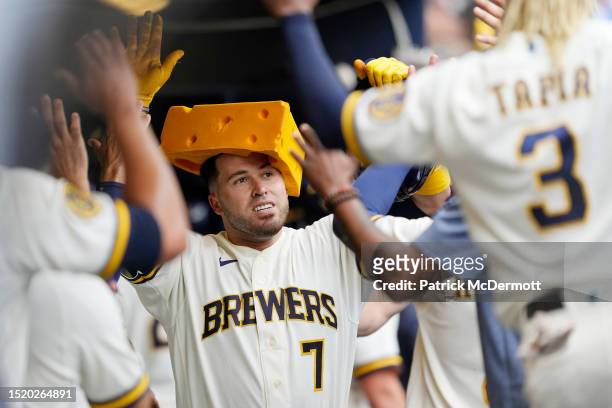 Victor Caratini of the Milwaukee Brewers celebrates in the dugout after hitting a solo home run against the Chicago Cubs in the eighth inning at...