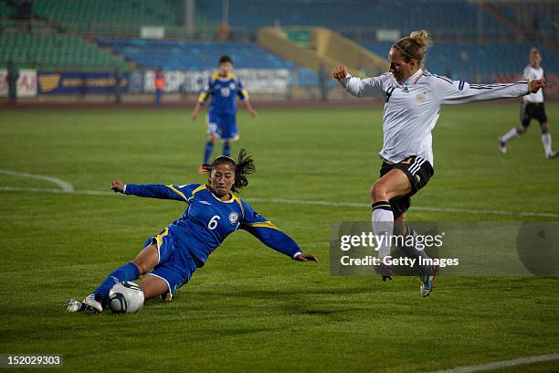 Ulbosin Zholchiyeva of Kazakhstan challenges Kim Kulig of Germany during the Women's Euro 2013 qualifying match between Kazakhstan and Germany at...