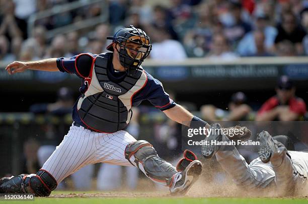 Orlando Hudson of the Chicago White Sox slides safely as Drew Butera of the Minnesota Twins defends home plate during the ninth inning on September...