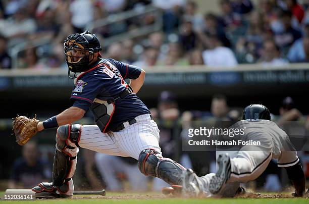 Orlando Hudson of the Chicago White Sox slides safely as Drew Butera of the Minnesota Twins defends home plate during the ninth inning on September...