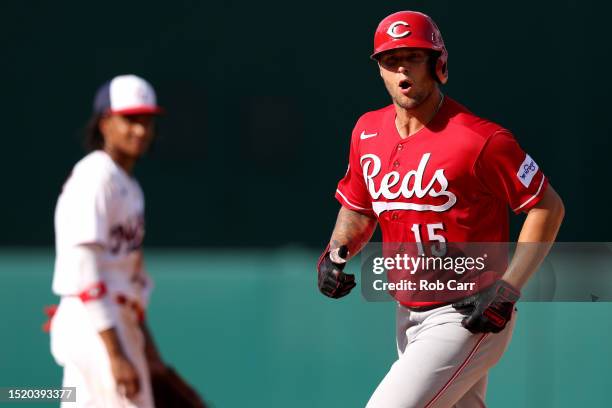 Nick Senzel of the Cincinnati Reds celebrates in front of CJ Abrams of the Washington Nationals after hitting a two RBI home run in the 10th inning...