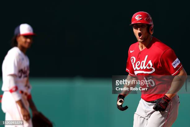 Nick Senzel of the Cincinnati Reds celebrates in front of CJ Abrams of the Washington Nationals after hitting a two RBI home run in the 10th inning...