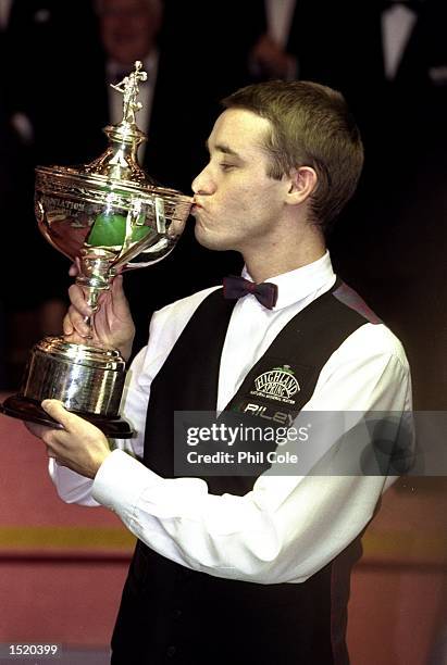 Stephen Hendry of Scotland celebrates victory with the trophy after winning the 1999 Embassy World Snooker Championships Final match against Mark...