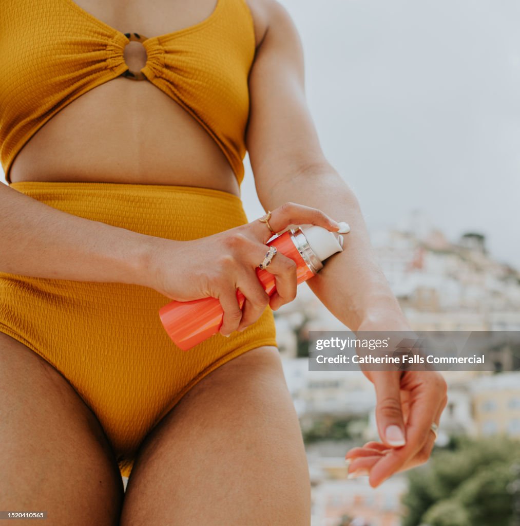 A woman pumps sunscreen onto her arm