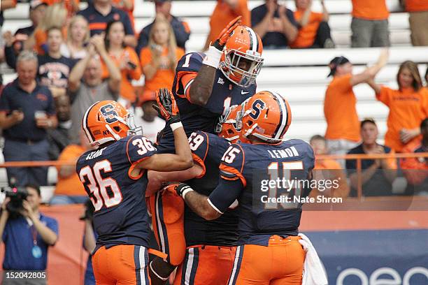 Ashton Broyld of the Syracuse Orange celebrates after a touchdown with teammates Christopher Clark, Alec Lemon and Macky MacPherson during the game...