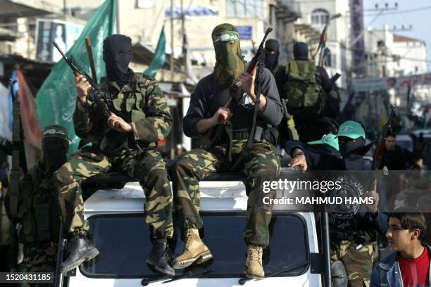 Palestinian militants from the Ezz al-Din al-Qassam Brigades, the militarily wing of the Hamas movement, take part in the funeral of one of its...