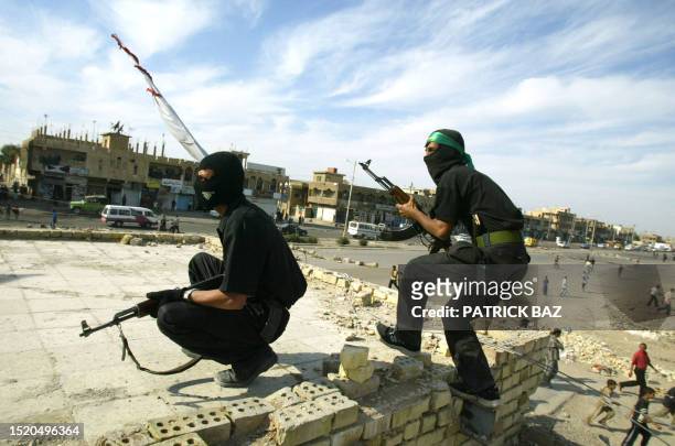 Members of radical Shiite leader Moqtada Sadr's Army of Mehdi militia, take position on a rooftop during skirmish with US troops 08 April 2004 in...