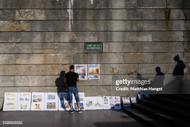 Street artist displays his work at the Pont de la Bourdonnais on July 06, 2023 in Paris, France. Paris will host the Summer Olympics from July 26...