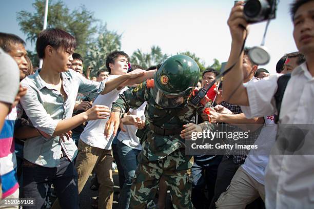 Anti-Japanese protesters crowd around a police officer as they demonstrate over the disputed Diaoyu Islands, on September 16, 2012 in Shenzhen,...