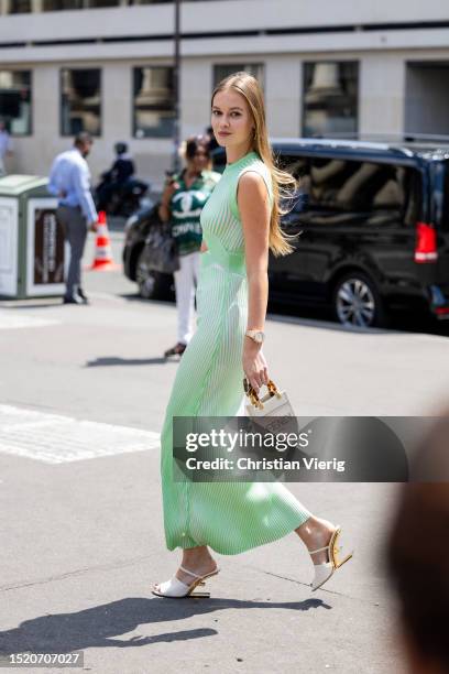 Guest is seen wearing green dress, bag with print, sandals outside Fendi during the Haute Couture Fall/Winter 2023/2024 as part of Paris Fashion Week...