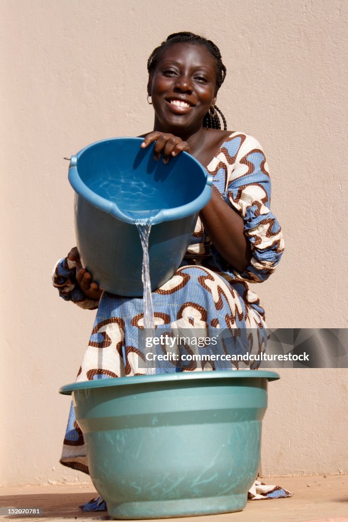 Woman pours water in bucket