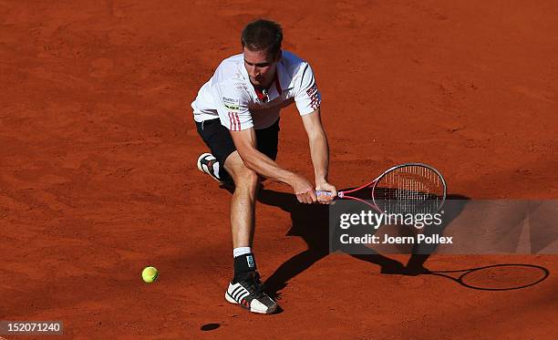 Florian Mayer of Germany returns the ball to Bernard Tomic of Australia during the Davis Cup World Group Play-Off match between Germany and Australia...