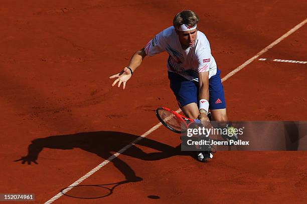 Cedrik-Marcel Stebe of Germany returns the ball to Lleyton Hewit of Australia during the Davis Cup World Group Play-Off match between Germany and...