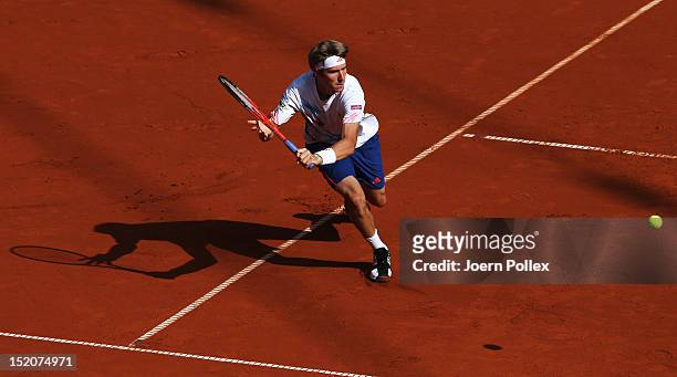 Cedrik-Marcel Stebe of Germany returns the ball to Lleyton Hewit of Australia during the Davis Cup World Group Play-Off match between Germany and...