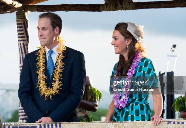 Catherine, Duchess of Cambridge and Prince William, Duke of Cambridge ride an open-top vehicle, shaped like a traditional canoe, at Honiara...