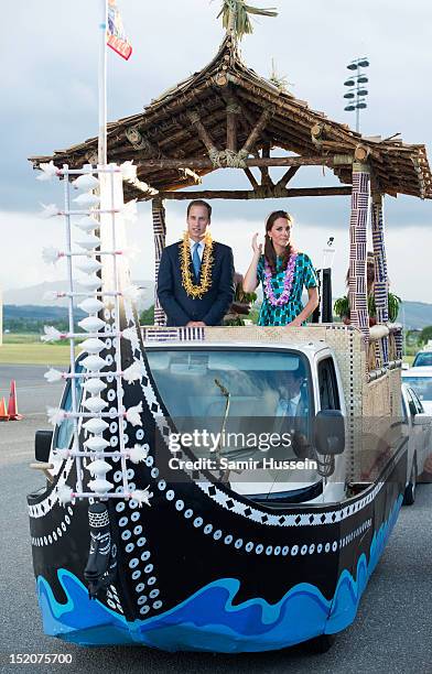 Catherine, Duchess of Cambridge and Prince William, Duke of Cambridge ride in an open-top vehicle, shaped like a traditional canoe, at Honiara...