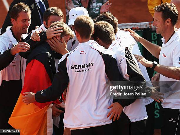 Cedrik-Marcel Stebe of Germany celebrates with his team after winning his match against Lleyton Hewitt of Australia during the Davis Cup World Group...