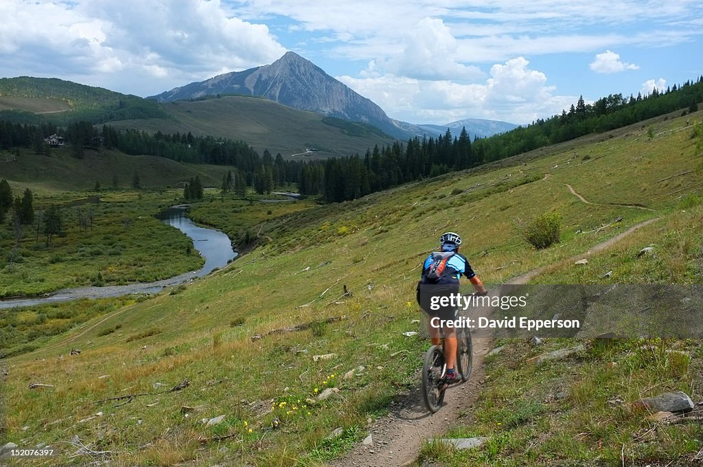 Man mountain biking on trail in Crested Butte