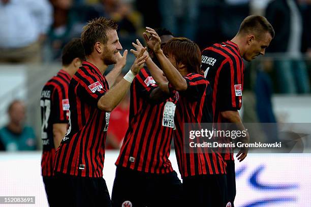 Stefan Aigner of Frankfurt celebrates with teammate Takashi Inui after scoring his team's third goal during the Bundesliga match between Eintracht...