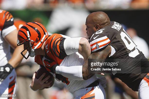Andy Dalton of the Cincinnati Bengals is tackled by Juqua Parker of the Cleveland Browns during their game at Paul Brown Stadium on September 16,...