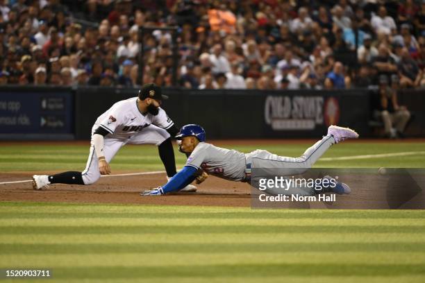 Francisco Lindor of the New York Mets slides safely into third base with a triple as Emmanuel Rivera of the Arizona Diamondbacks waits on the throw...