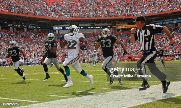 Reggie Bush of the Miami Dolphins rushes for a touchdown during a game against the Oakland Raiders at Sun Life Stadium on September 16, 2012 in Miami...