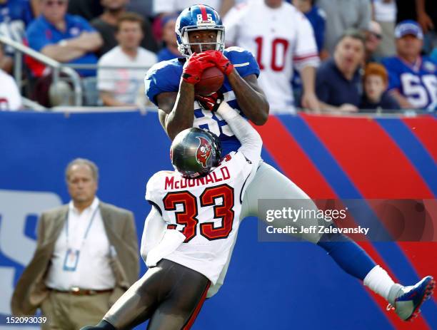 Martellus Bennett of the New York Giants pulls in a pass for a touchdown with coverage by Brandon McDonald of the Tampa Bay Buccaneers during a game...