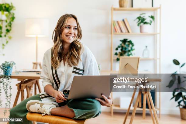 woman with a nice smile sitting relaxed in her modern office. - laptop stock-fotos und bilder