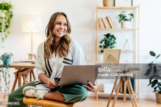 woman with a nice smile sitting relaxed in her modern office. - one empty desk stock pictures, royalty-free photos & images