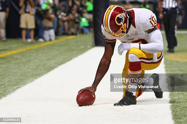 Robert Griffin III of the Washington Redskins 'Tebows' in celebration after scoring a touchdown against the St. Louis Rams at the Edward Jones Dome...