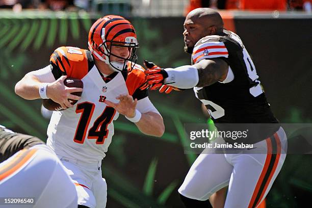 Quarterback Andy Dalton of the Cincinnati Bengals is chased by a helmetless Juqua Parker of the Cleveland Browns in the first half at Paul Brown...