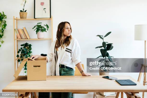young woman in her home office pondering her future. - one empty desk stock pictures, royalty-free photos & images