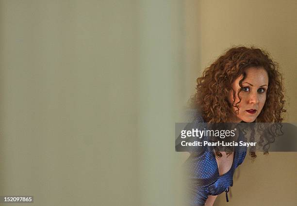 woman peeking around corner - daly city stock pictures, royalty-free photos & images
